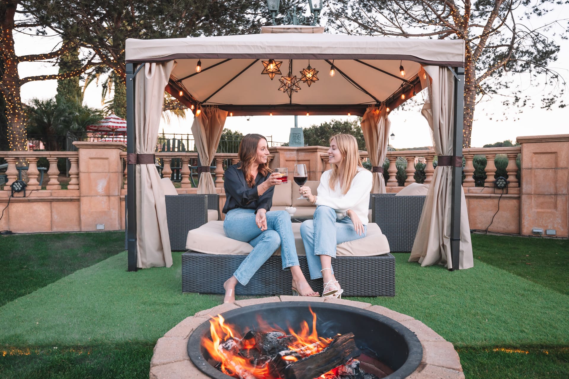two friends enjoying a drink near the fireplace