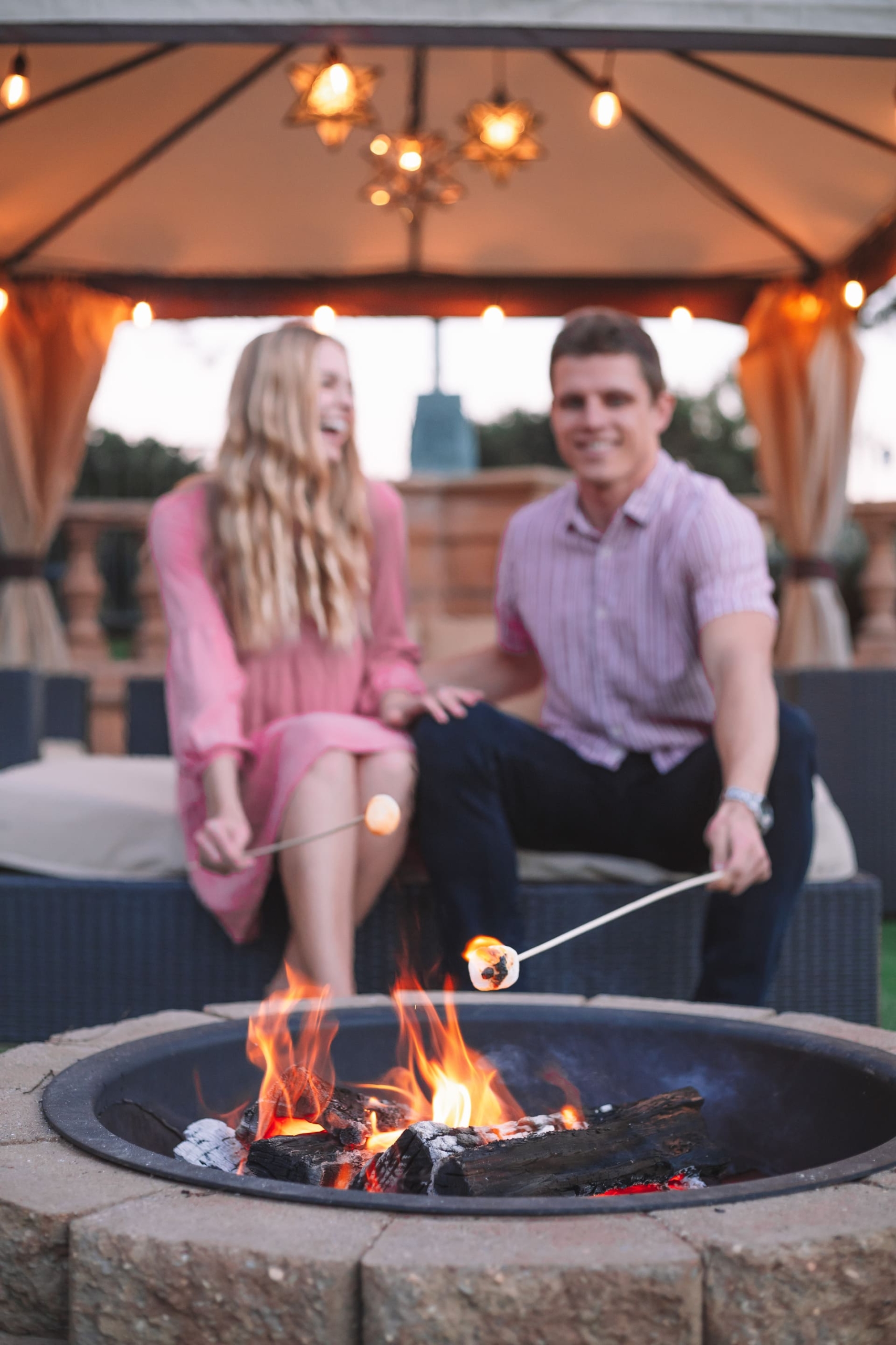 a man and woman roasting marshmellows