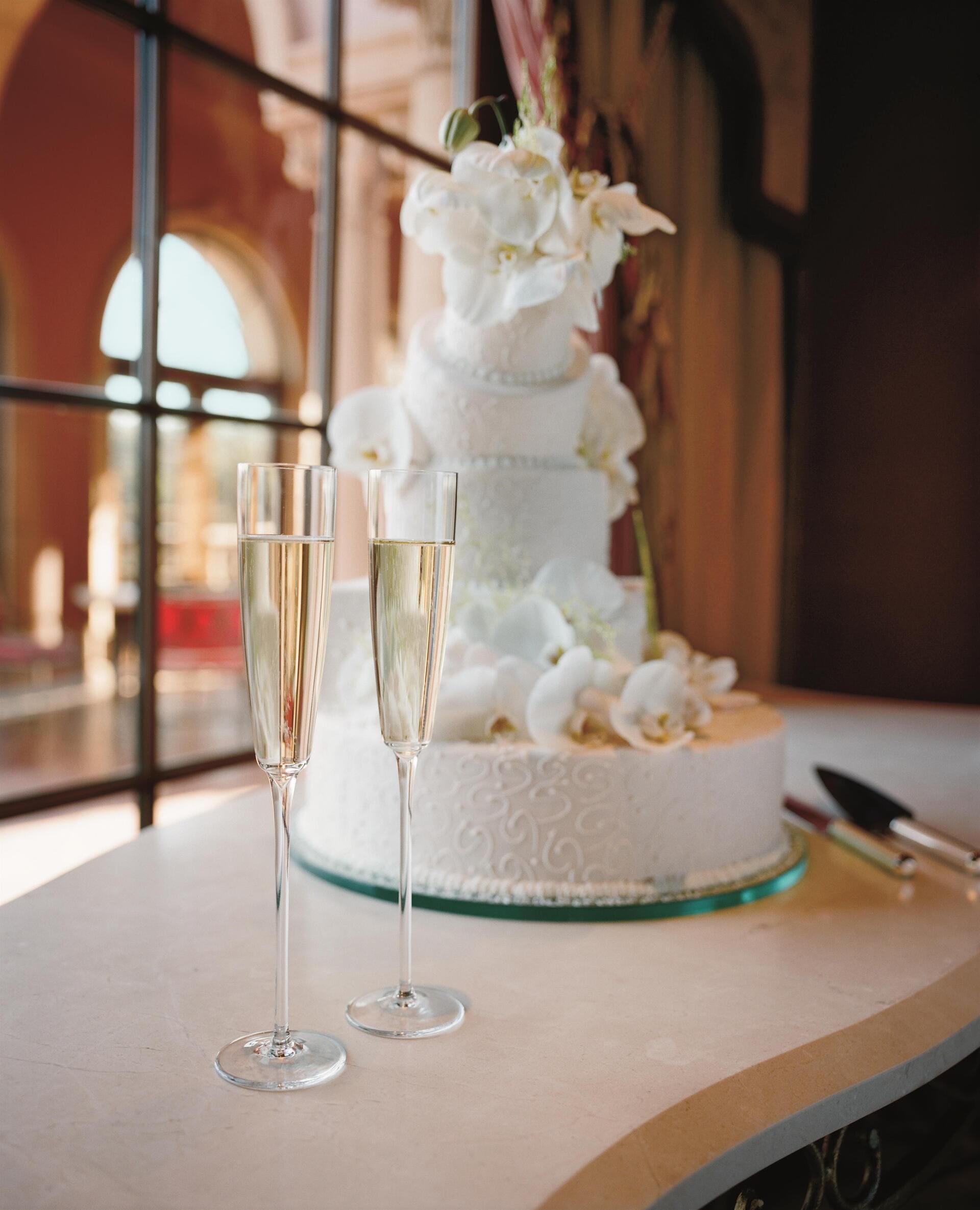 a wedding cake next two two glasses of champagne