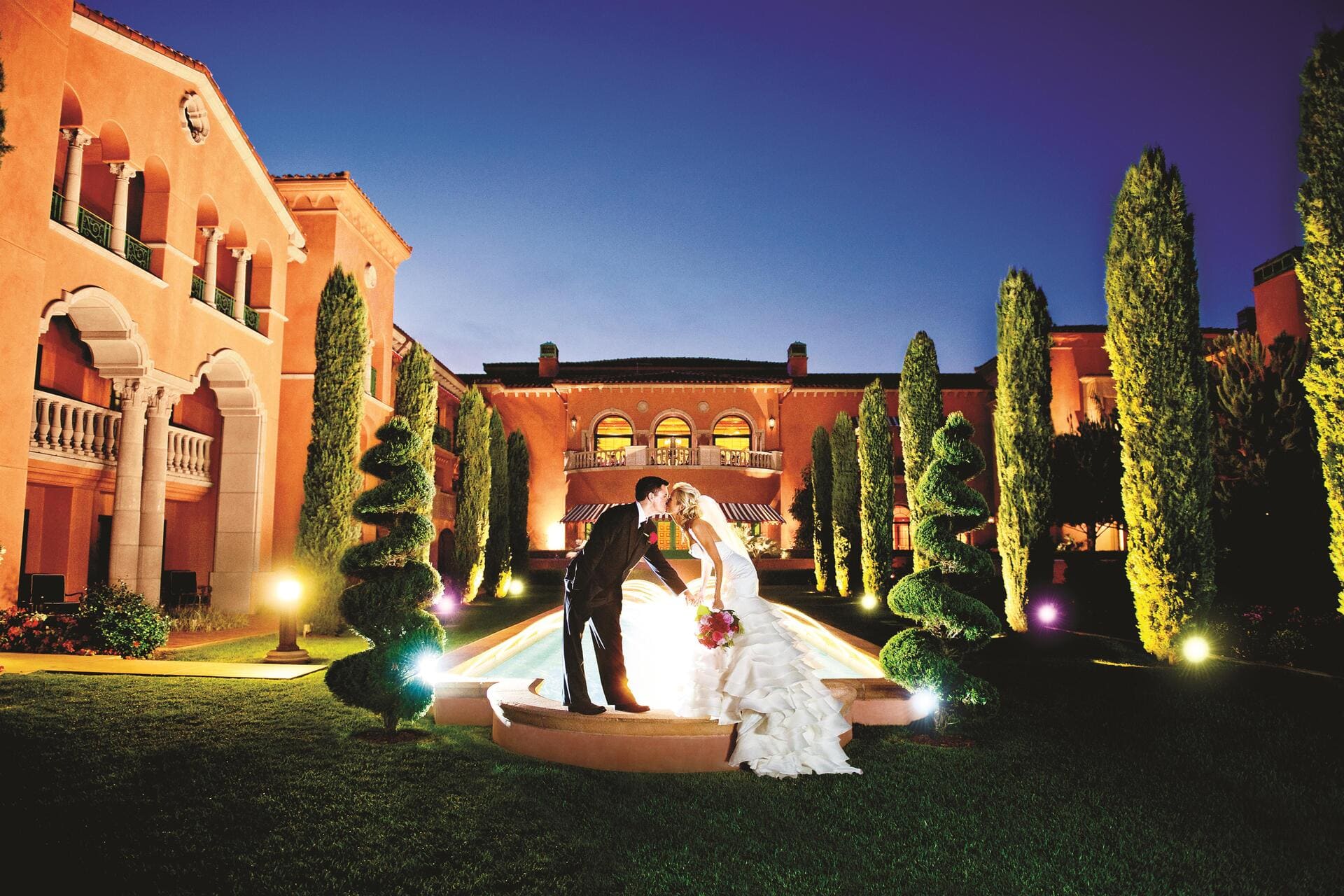 Bride and groom kissing in the courtyard