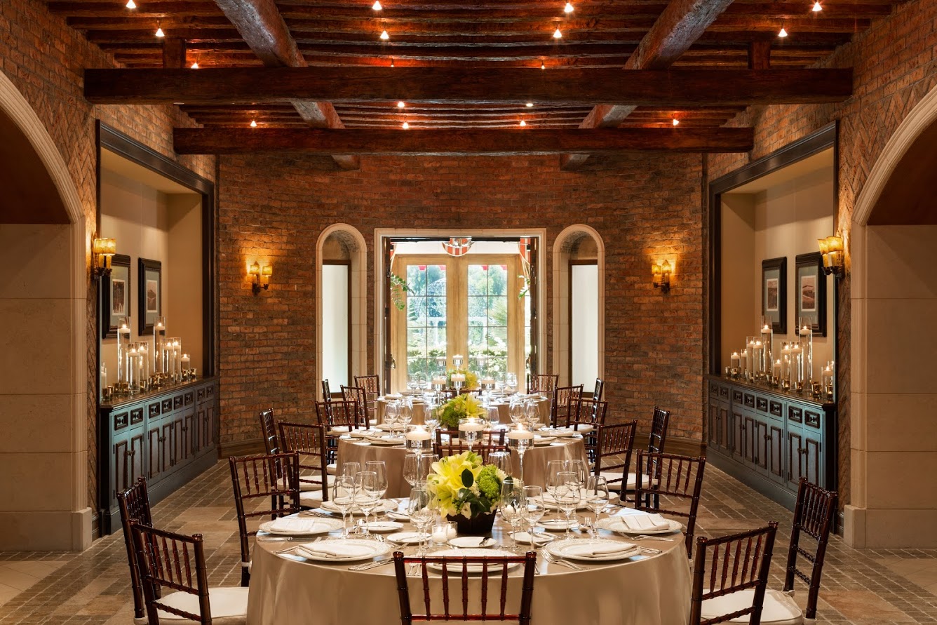 Three round tables fully set in rustic room