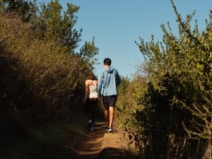 Man and woman hiking through trail.