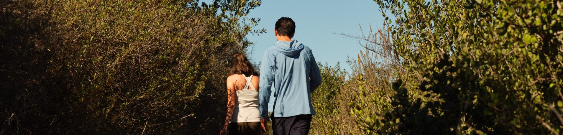 Man and woman hiking through trail.